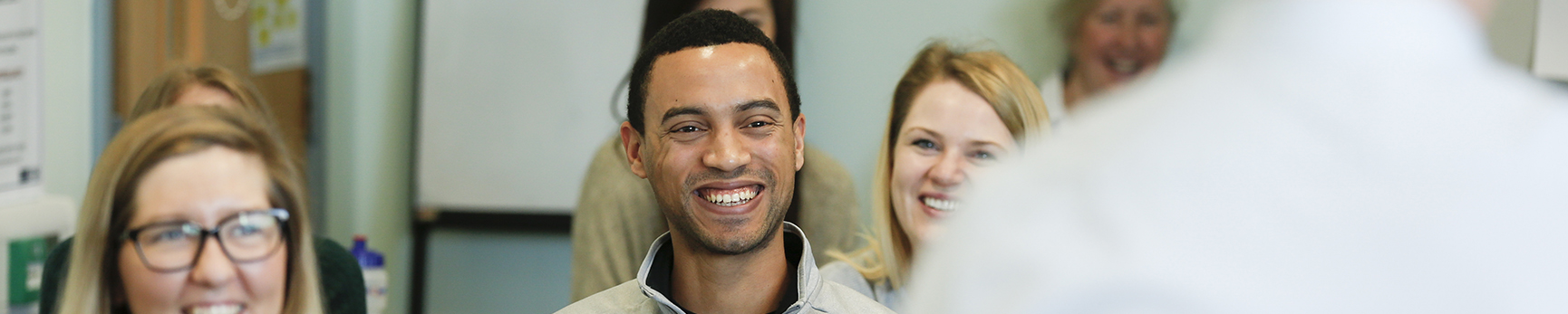 postgraduate student smiling towards camera during a lecture