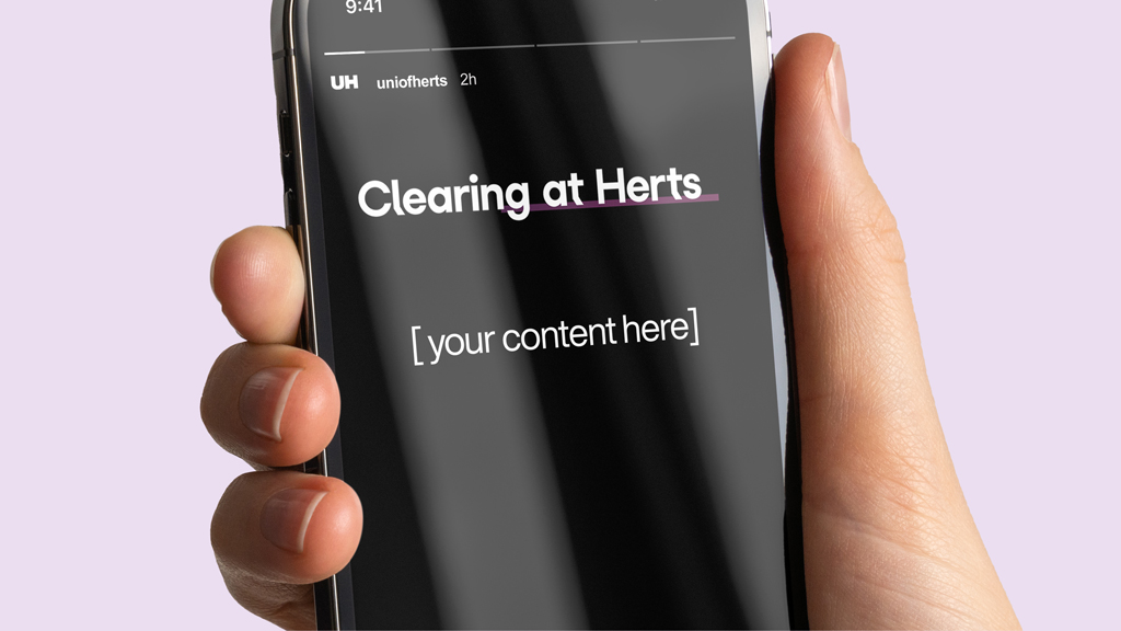 A hand holding an iPhone displaying an Instagram post from the University of Hertfordshire